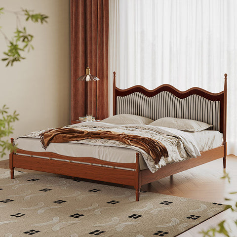 Liam super king wooden bed with curved striped upholstered headboard and footboard dressed in white linens and brown throw