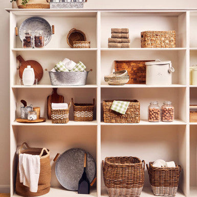 Woven wicker storage baskets in natural tones feature varied sizes and patterns in the lidi oval jute basket collection