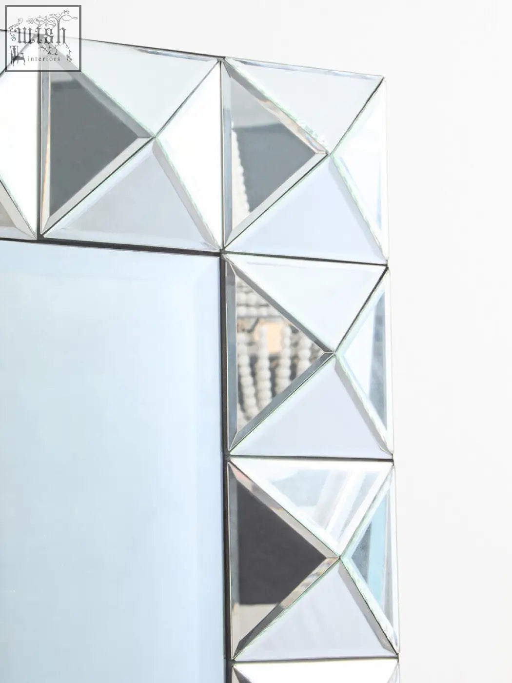 Lidia 3d effect rectangular wall mirror with a silver geometric frame made of interlocking triangular mirrored segments