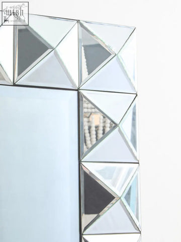 Lidia 3d effect rectangular wall mirror with a silver geometric frame made of interlocking triangular mirrored segments