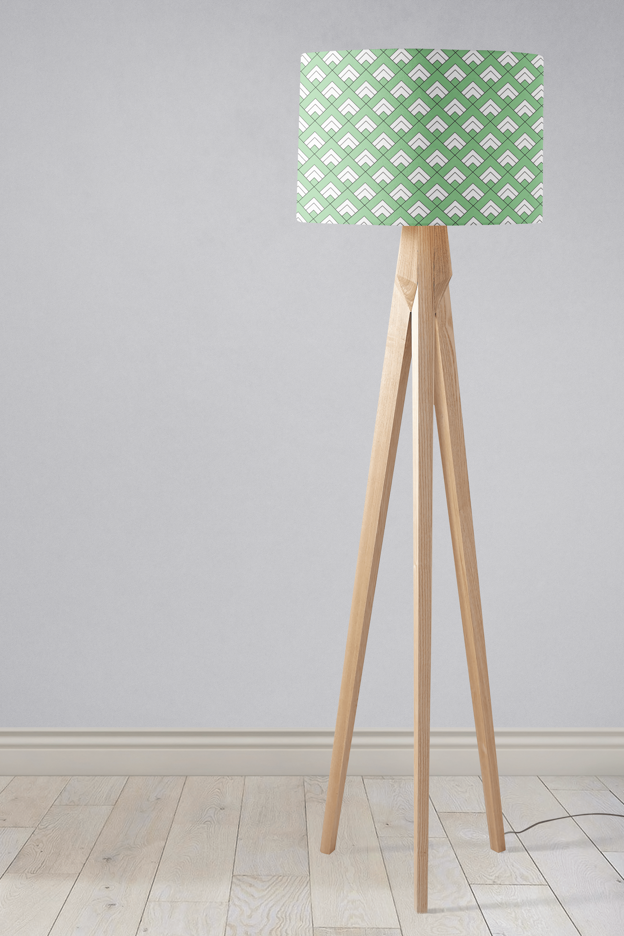 A modern tripod floor lamp with light wood finish and light green table lamp shade featuring white geometric tiles design