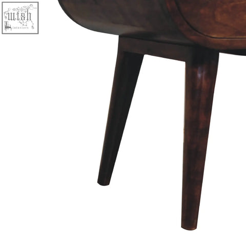 Dark brown wooden legs with a smooth polished finish on a light walnut circular bedside with open slot table