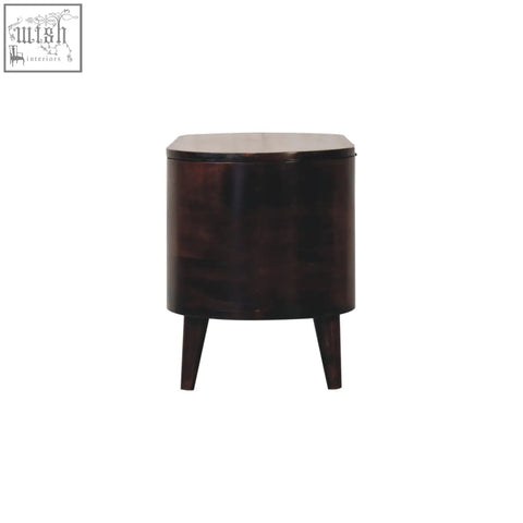 Dark brown wooden cylindrical side table with four tapered legs shown alongside light walnut rounded lid-up blanket box storage bench