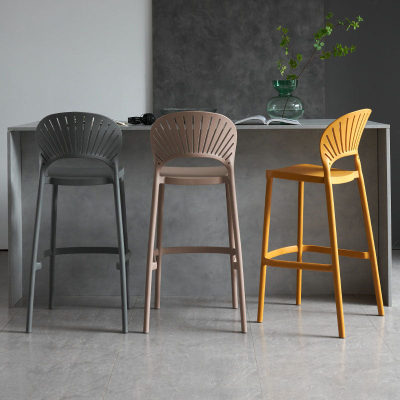 Three lilith bar stools with sleek fan-shaped backrests in gray beige and mustard yellow for modern seating