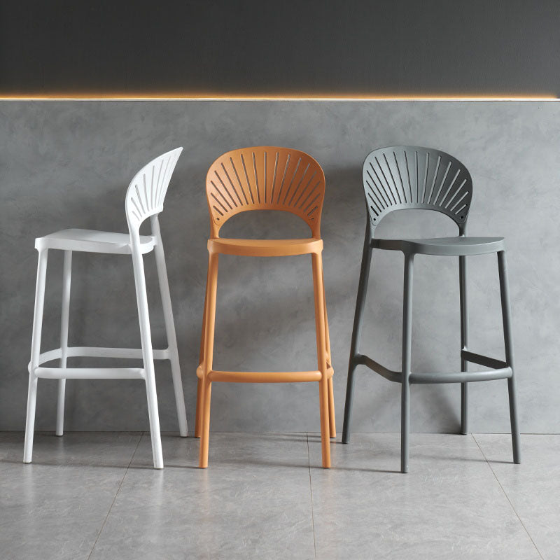 Three lilith bar stools in white orange and gray with sleek molded plastic fan-shaped backrests