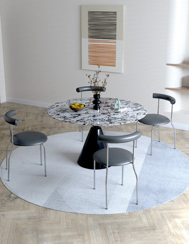 Round marble-top dining table with sleek black conical base perfect for lillian round dining setups
