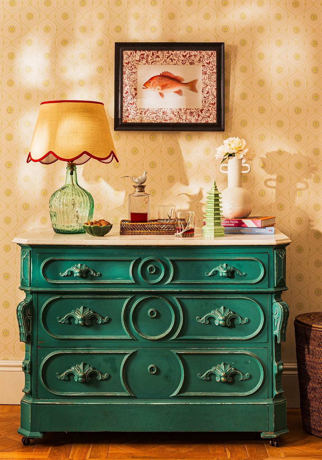 Teal-green antique-style wooden dresser with ornate carved drawers and decorative handles in minimalist style