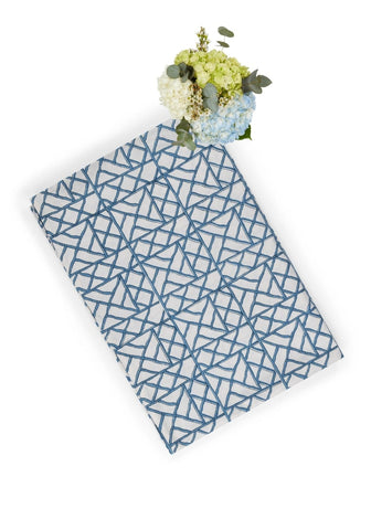 A rectangular notebook with a white cover and blue geometric lattice pattern inspired by lily’s blue bamboo breeze tablecloth
