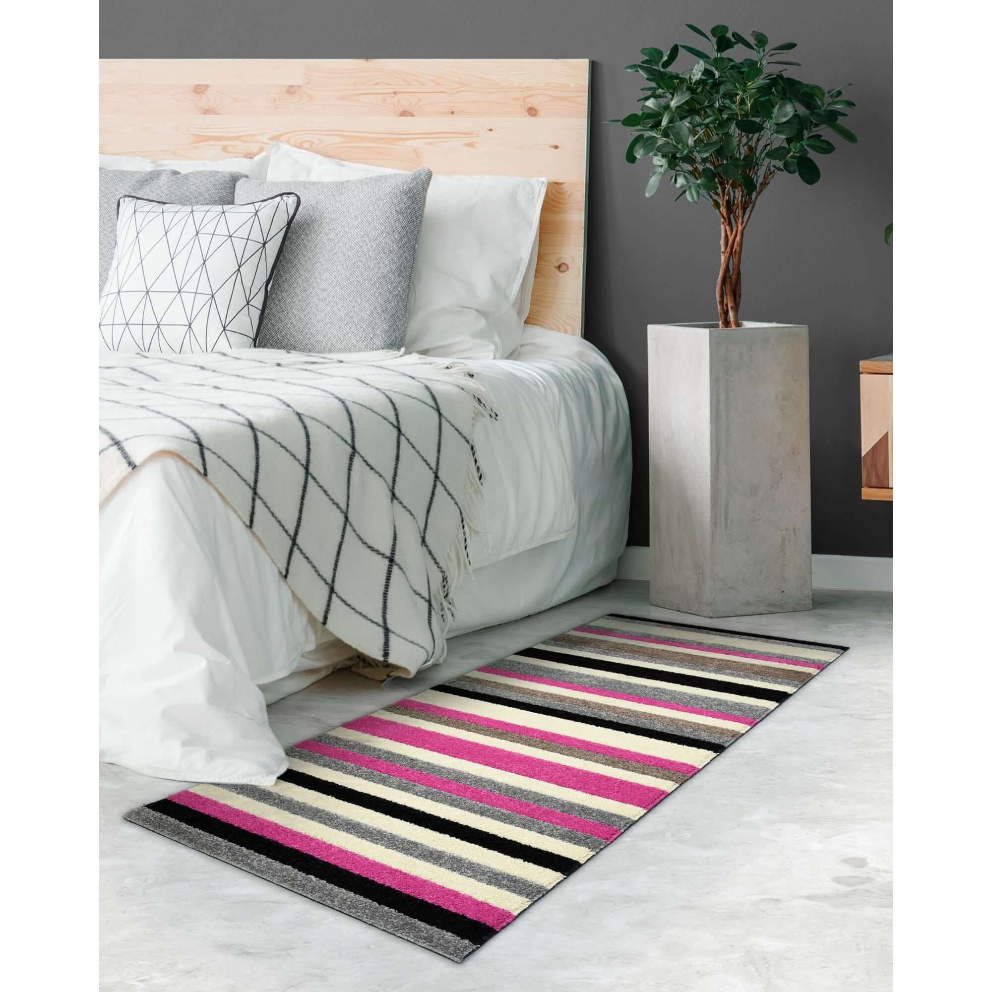 A vibrant linea striped pink washable runner rug with bold pink black gray and cream horizontal stripes