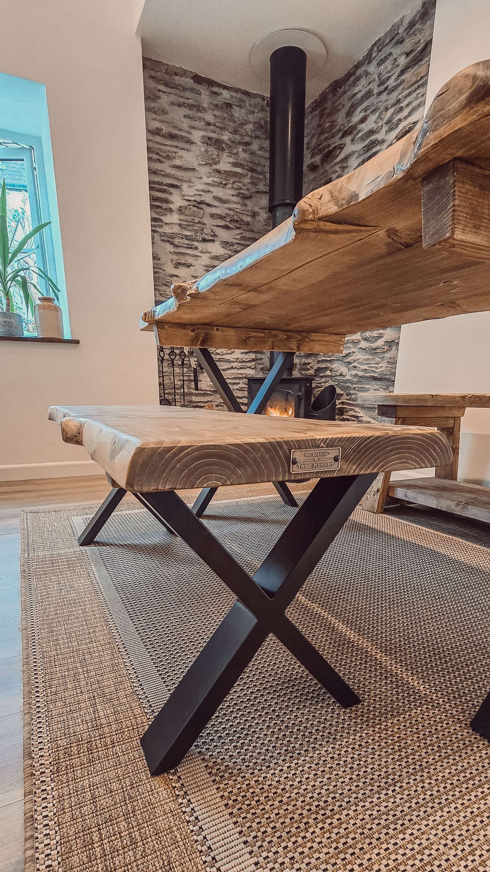 Rustic waney edge dining table with natural live edge wooden top and black x cross metal legs