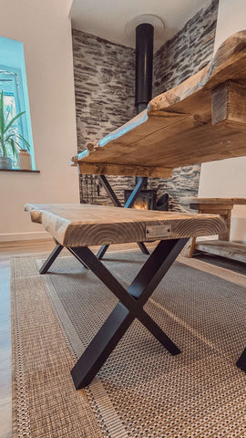 Rustic waney edge dining table with natural live edge wooden top and black x cross metal legs