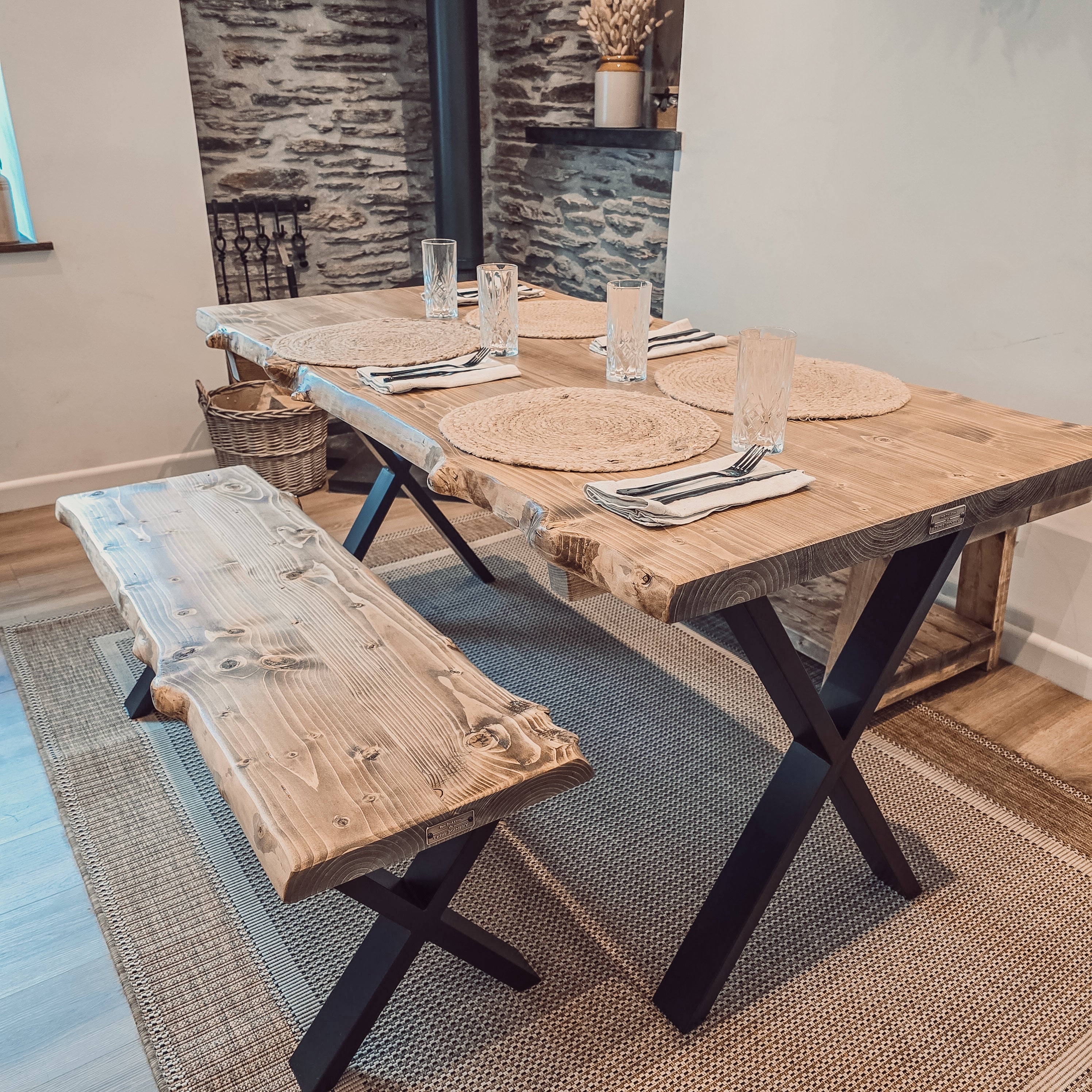 Rustic waney edge dining table with live edge wooden top and black x cross metal legs for stylish edge dining