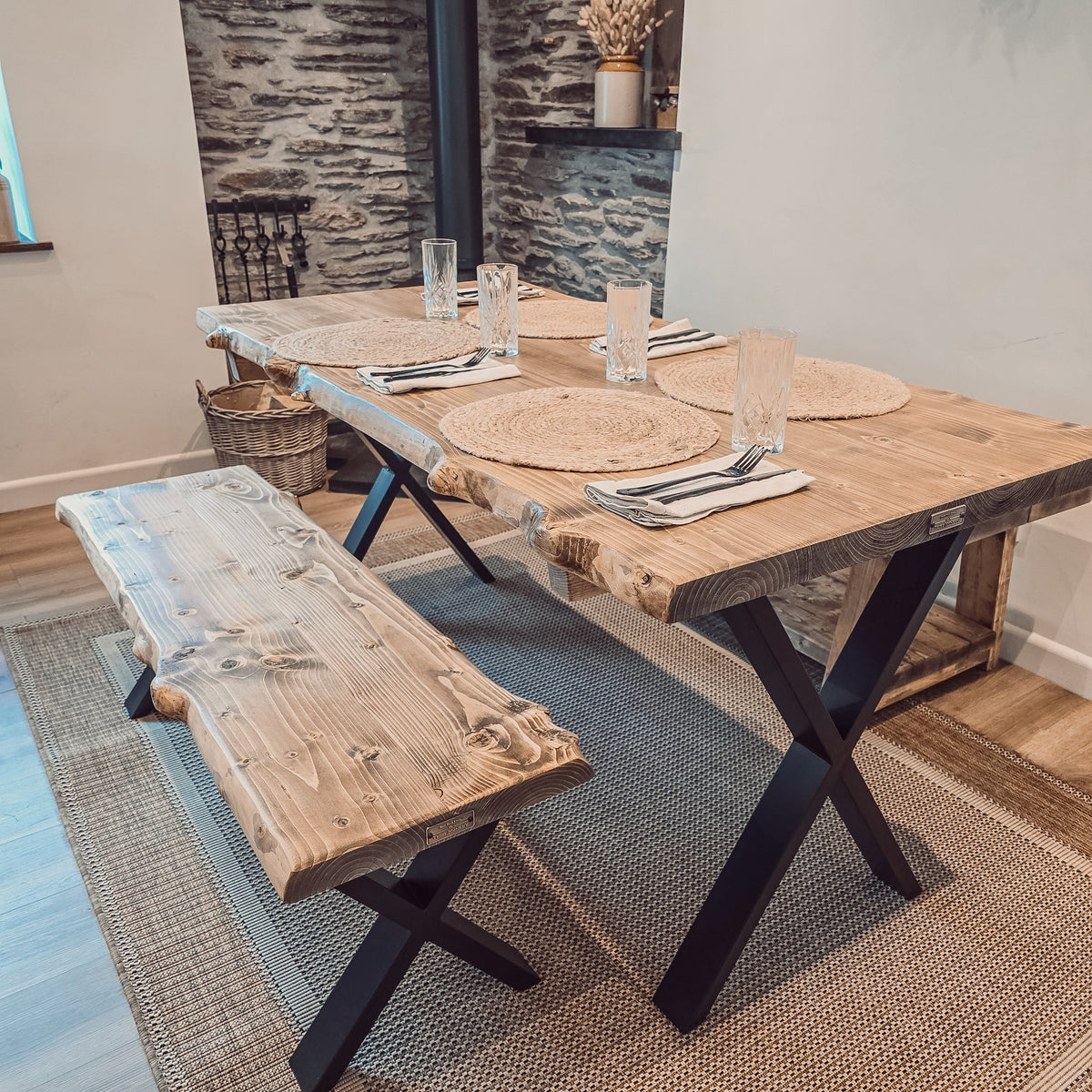 Rustic waney edge dining table with live edge wooden top and black x cross metal legs for stylish edge dining