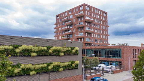 Red brick apartment with balconies featuring a living wall using interchangeable plant cassettes from livepanel outdoor living wall
