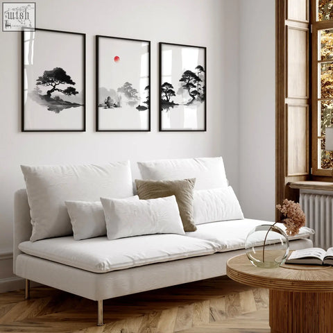 White upholstered sofa with metal legs and cushions below japandi zen landscape black white red sun living room picture set of 3