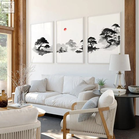 Three framed black and white ink wash japandi living room pictures with red sun above a white sofa set of 3
