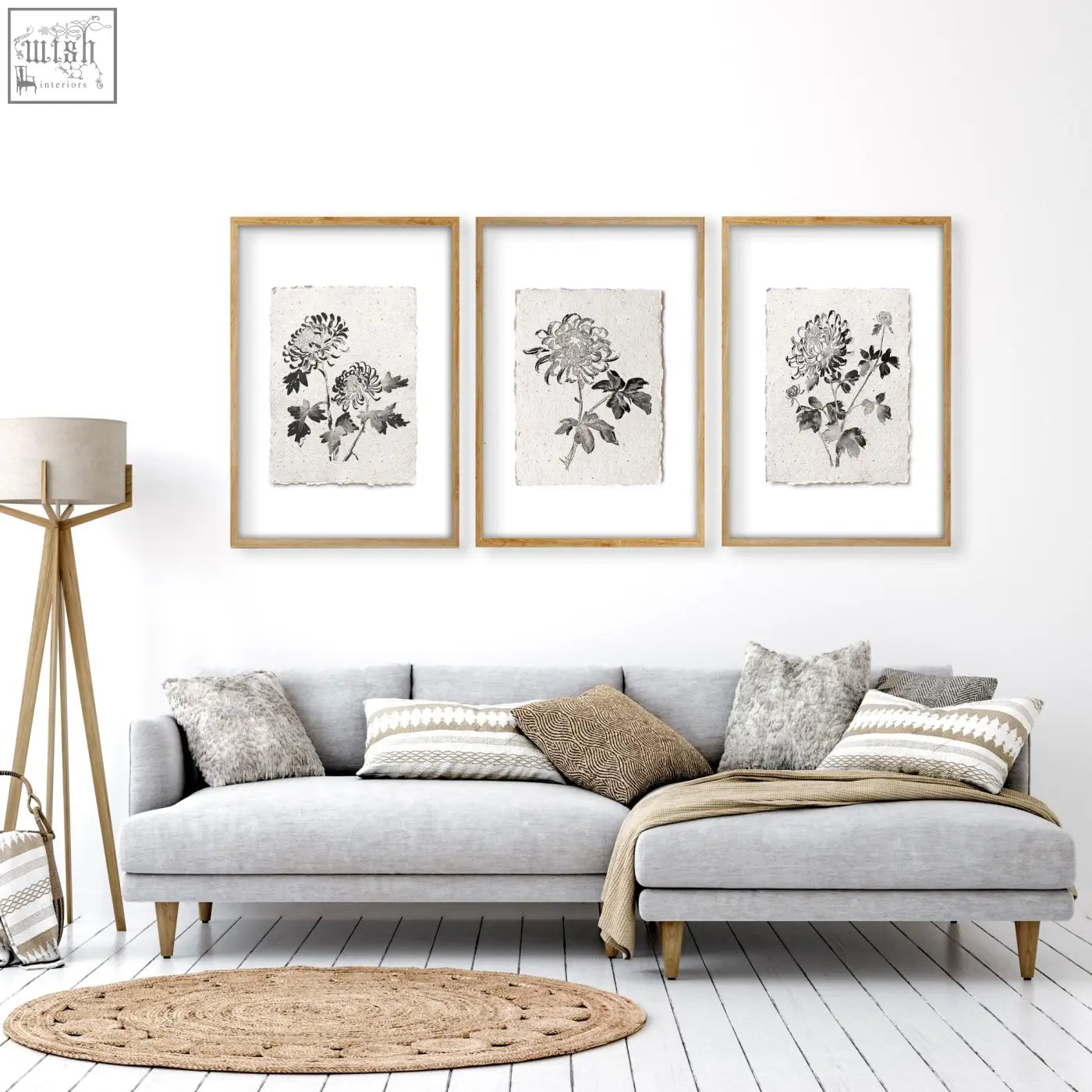 Three framed living room prints featuring black botanical chrysanthemum ink on off-white paper in light wood frames