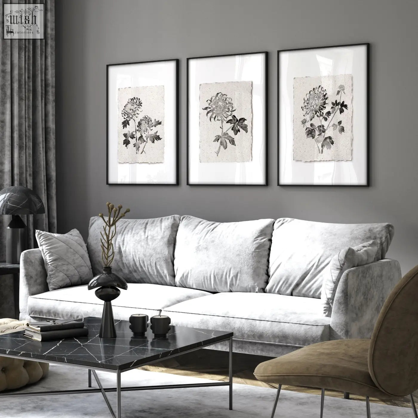 Gray velvet sofa with plush cushions next to living room prints featuring botanical chrysanthemum in beige and black