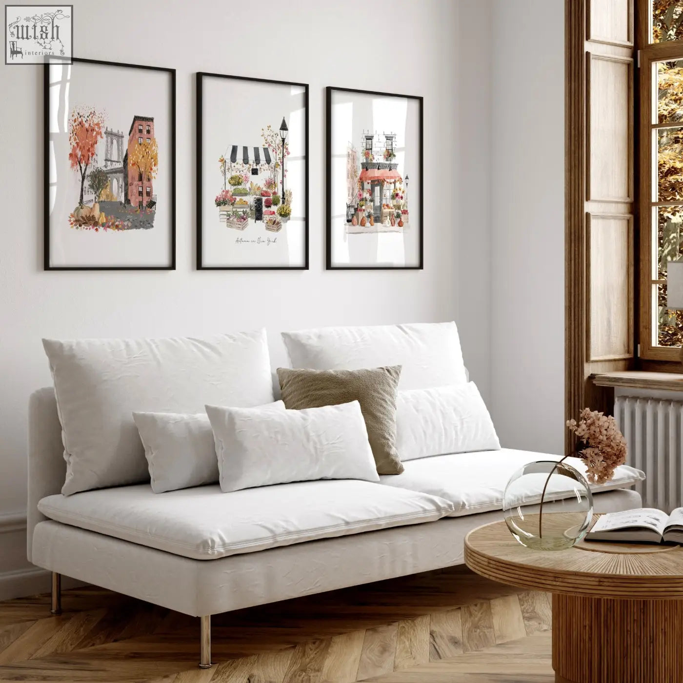 White upholstered sofa with metallic legs and cushions below autumn in new york living room wall art set of 3