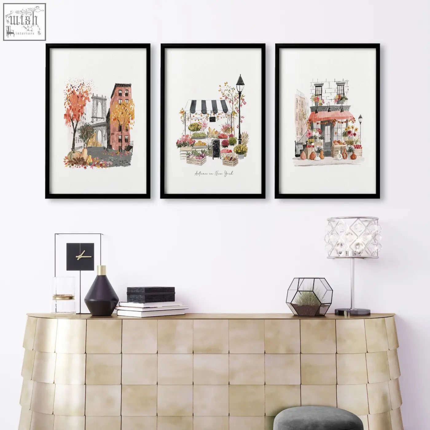 Three black-framed watercolor prints of new york city scenes hang above a gold console table as living room wall art