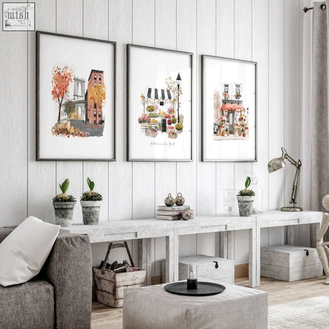 Three framed autumn in new york watercolor prints displaying nyc scenes hang on a white wall as living room wall art