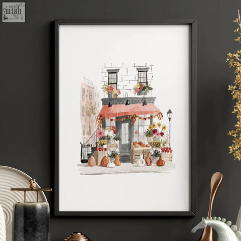 Black-framed watercolor wall art of autumn in new york flower shop with orange awning perfect for living room wall decor