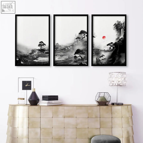 Three framed black and white japanese ink landscape wall art with red sun displayed above metallic console table for living room wall