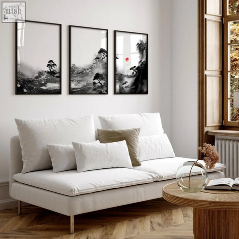 White upholstered sofa with metallic legs and cushions in a living room with japanese ink landscape wall art set of 3