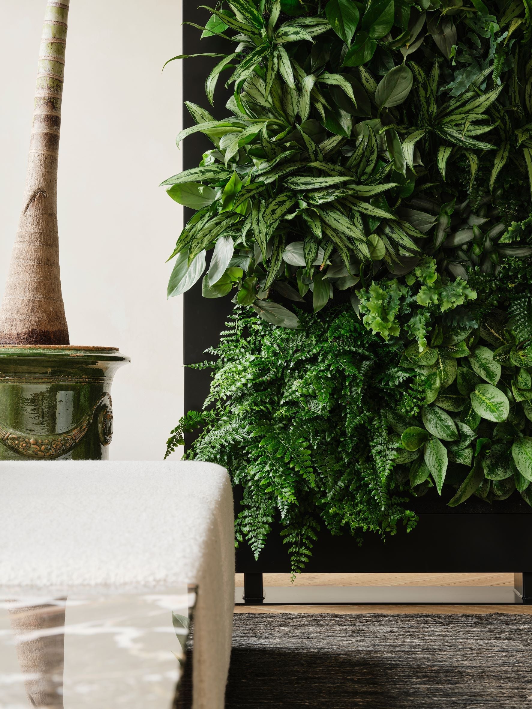 A lush living wall divider 180.5cm tall in black featuring vertical green plants with varied leaves and textures