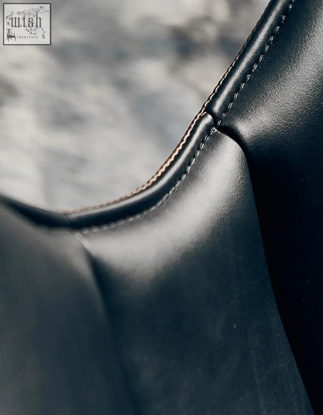 Black leather lobster lounge chair with precise contrasting stitching along the seam for stylish comfort