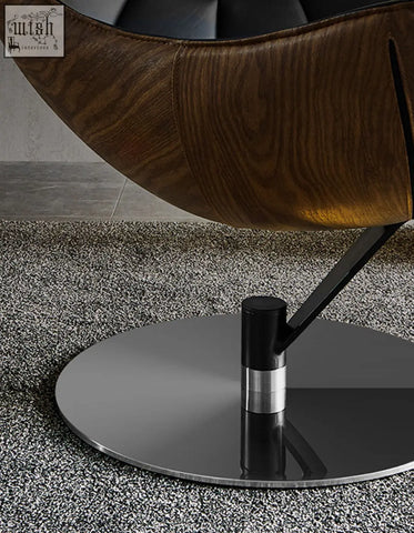 A sleek lobster lounge chair with a curved wooden shell and black metal base perfect for any lounge space