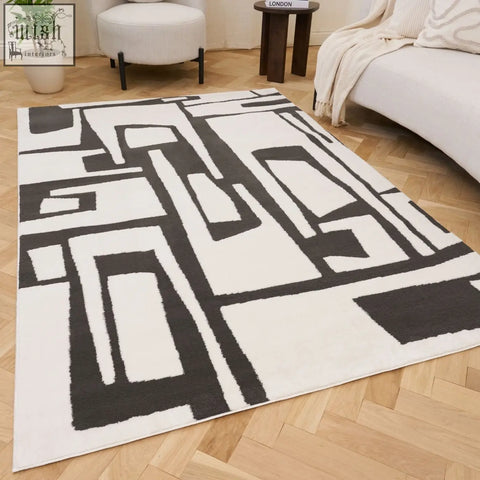 Modern abstract dark grey rug with bold black geometric patterns on plush cream background for loft spaces