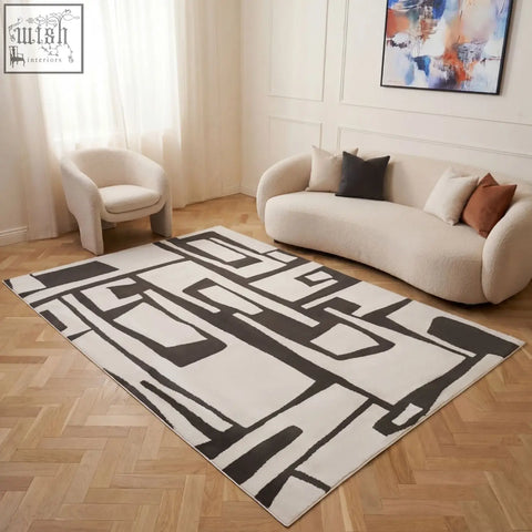Modern geometric loft abstract dark grey rug with bold black and cream patterns on a light wood floor