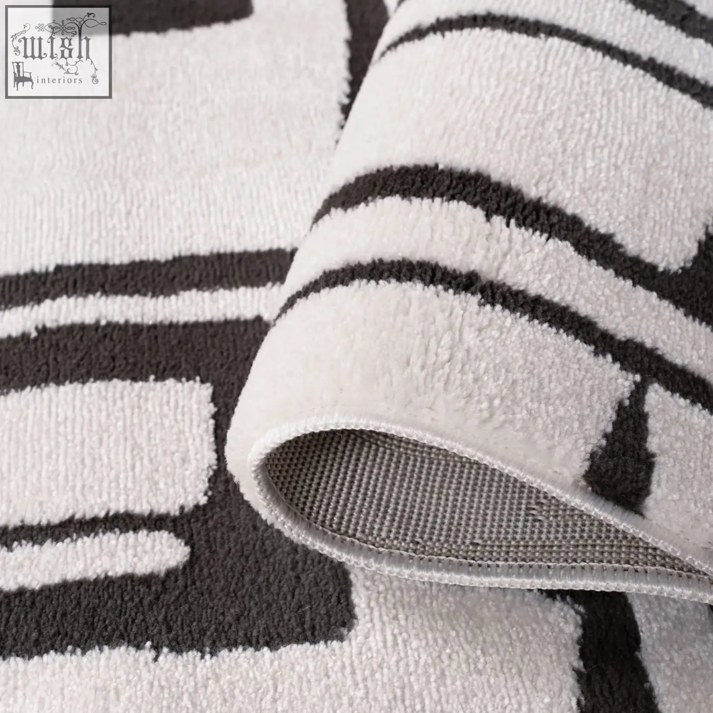 A plush loft abstract dark grey rug with a soft textured surface and a white and black geometric pattern