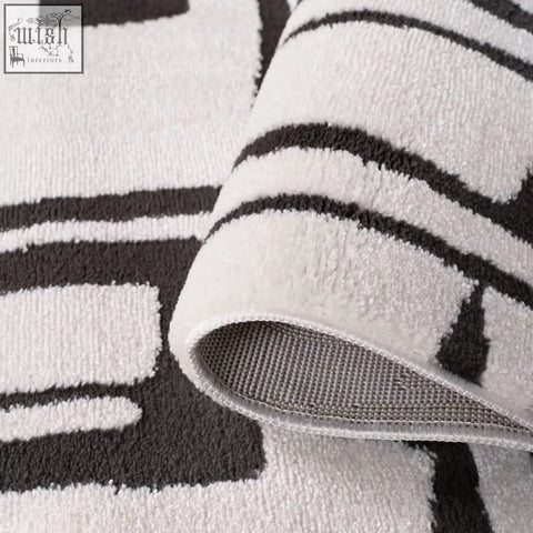 A plush loft abstract dark grey rug with a soft textured surface and a white and black geometric pattern