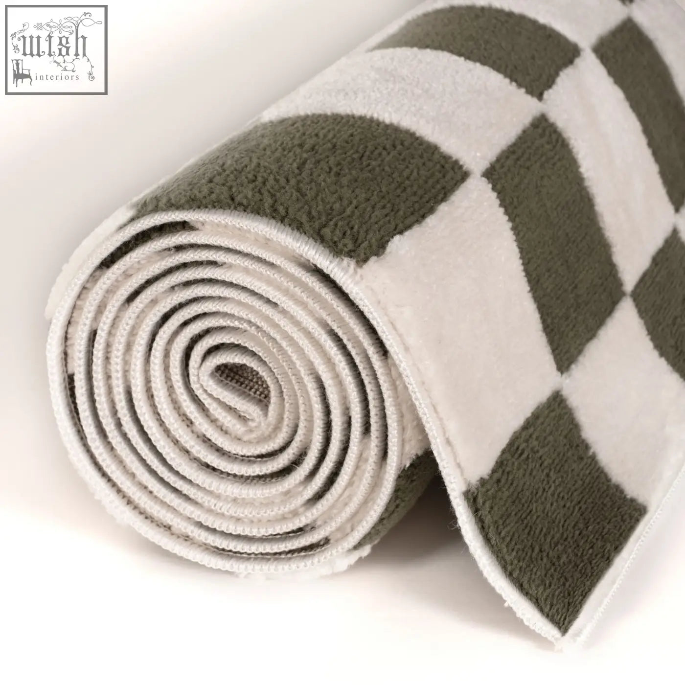A plush rolled bath towel with a bold olive green and white diamond pattern inspired by the loft checkerboard green rug