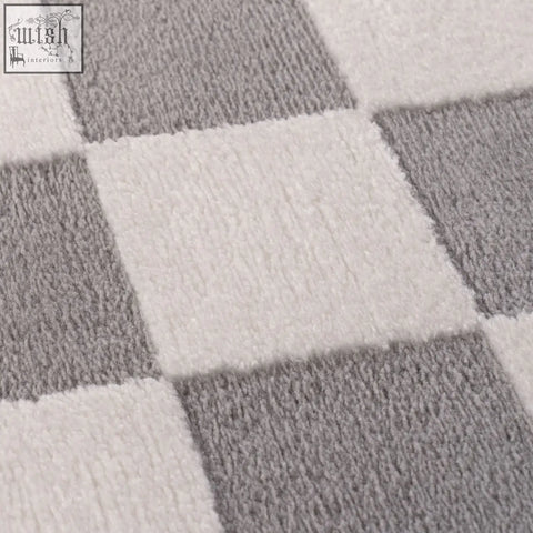 A plush soft-textured loft checkerboard grey rug with a classic grey rug pattern in off-white squares