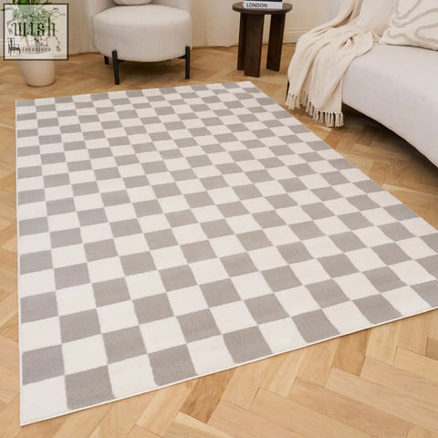 A soft plush rectangular loft checkerboard grey rug with a grey and white checkered pattern on wooden floor