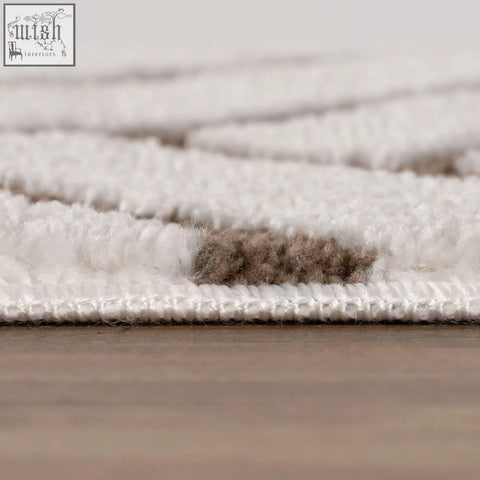A plush white and beige textured looped pile rug with geometric pattern for loft chevron brown style spaces