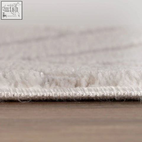 White plush chevron cream rug with soft textured surface and neatly stitched edge for cozy room decor