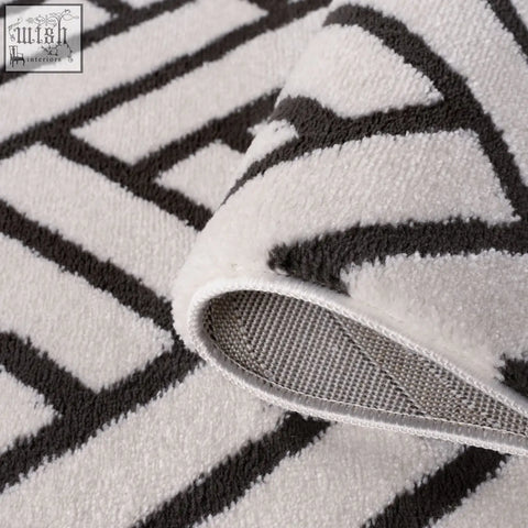 White and black plush bath rug with geometric loft chevron dark grey pattern and textured surface