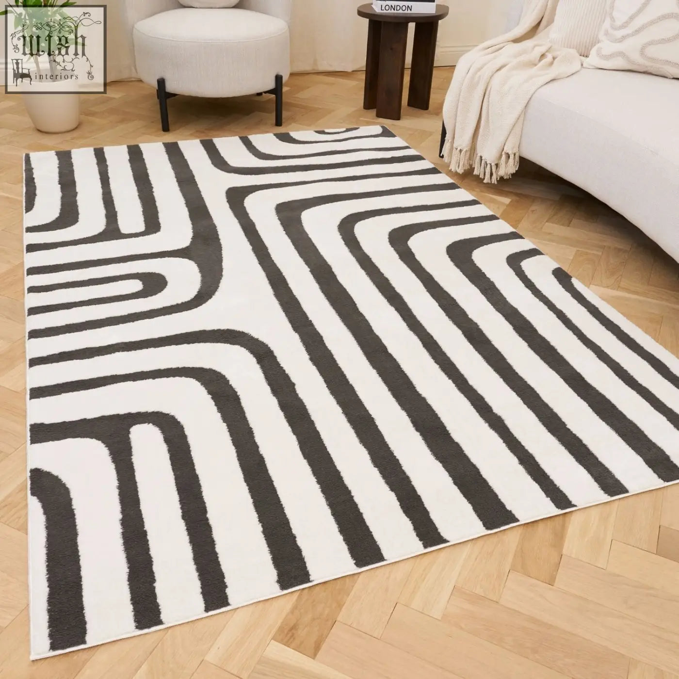 A modern dark grey rug with bold black and white geometric patterns and flowing lines perfect for loft spaces