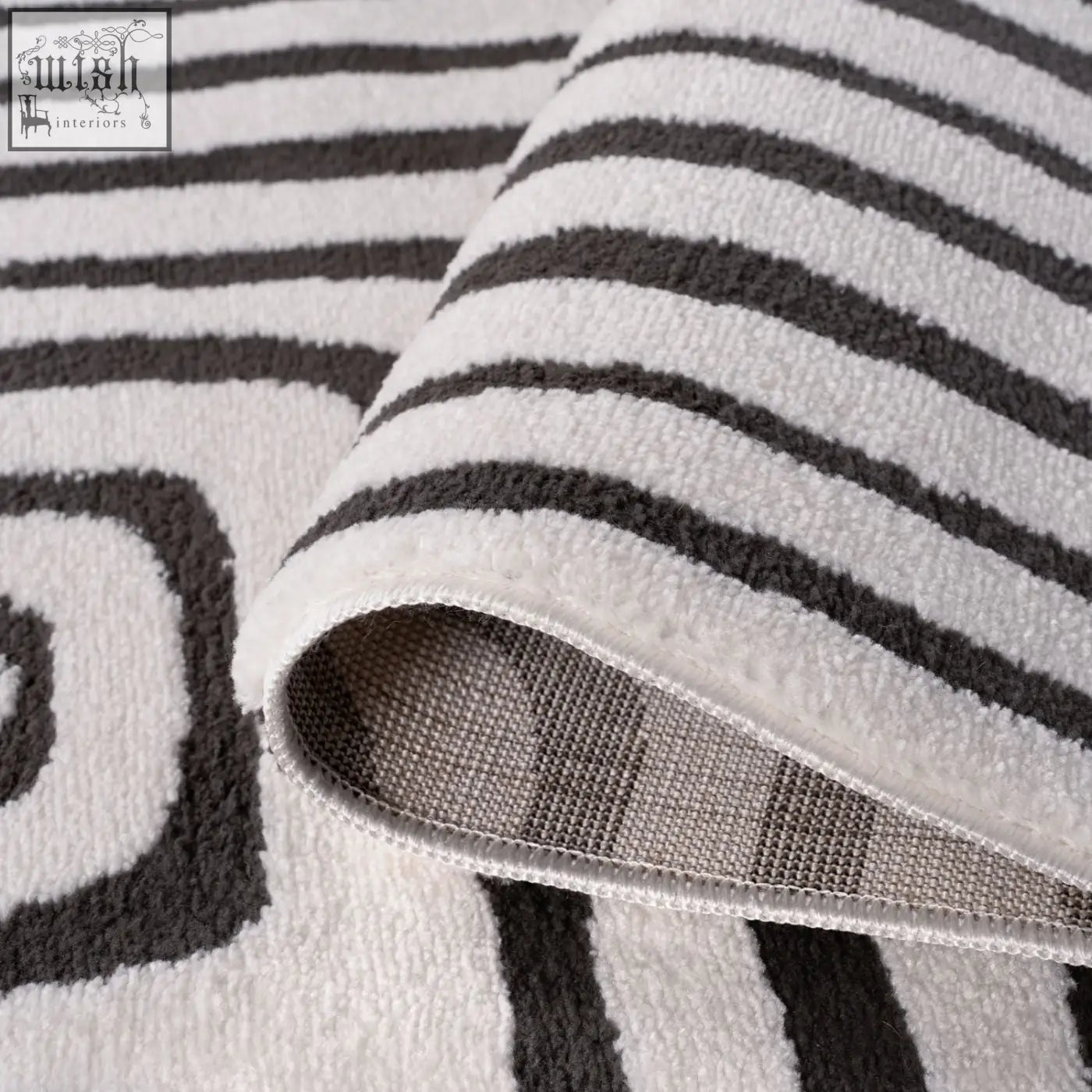 A plush loft geometric dark grey rug with white and charcoal striped soft textured surface