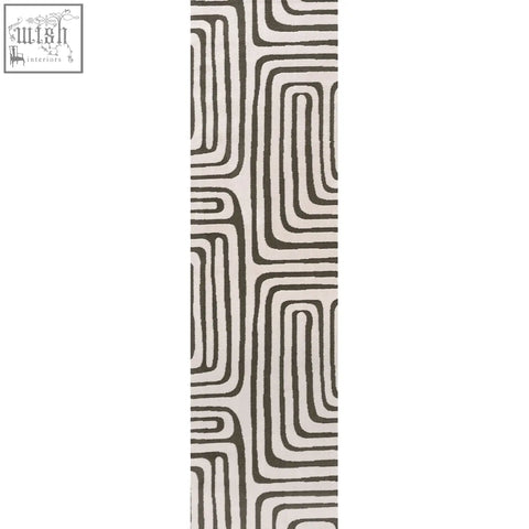 A long rectangular loft geometric green rug with bold black and cream abstract lines and a modern pattern