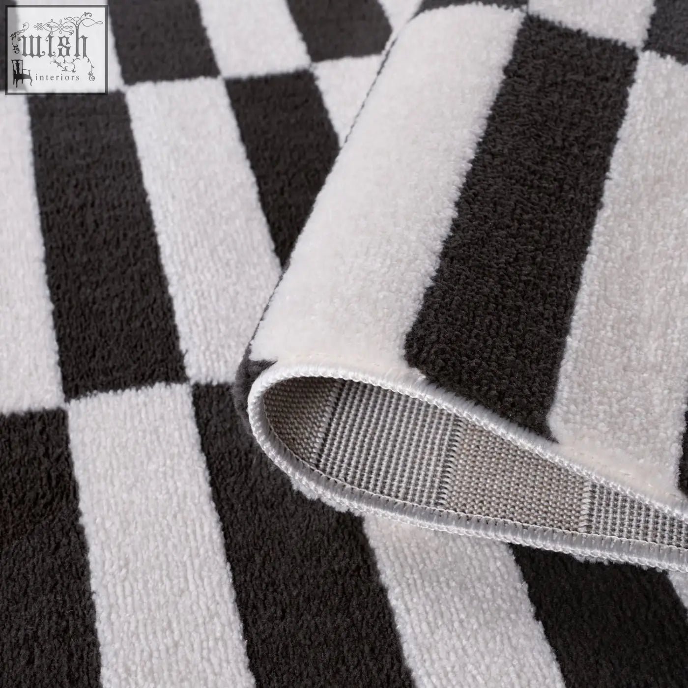 A plush dark grey rug with a soft textured surface in a stylish black and white checkered pattern