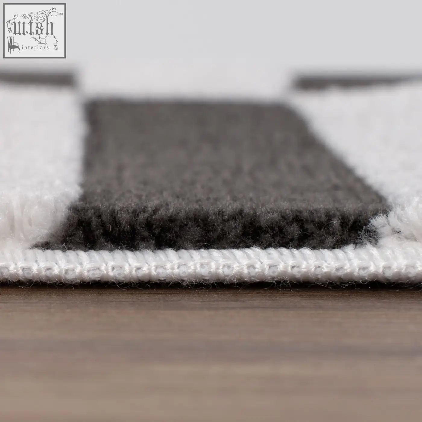 A plush dark grey rug with soft textured pile and striped grey and white design perfect for cozy spaces