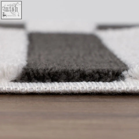 A plush dark grey rug with soft textured pile and striped grey and white design perfect for cozy spaces