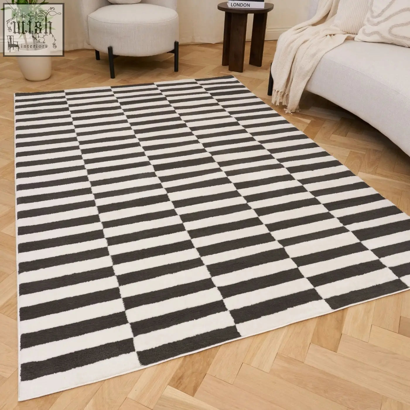 A plush dark grey rug with bold black and white diagonal stripes in a checkerboard pattern rectangular area rug