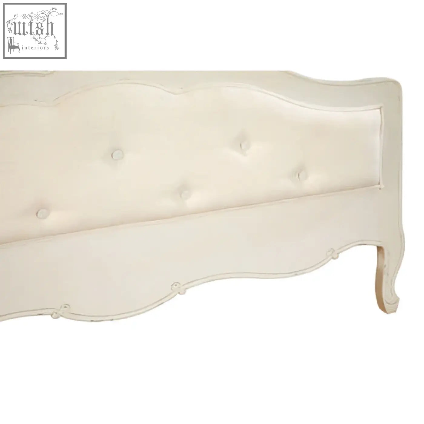 Cream-colored tufted headboard with soft upholstery and curved wooden frame on a loire white double bed