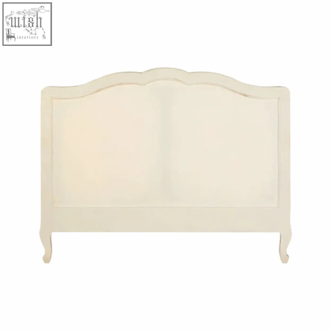 Cream-colored upholstered headboard with curved top and ornate wooden frame on a loire white double bed
